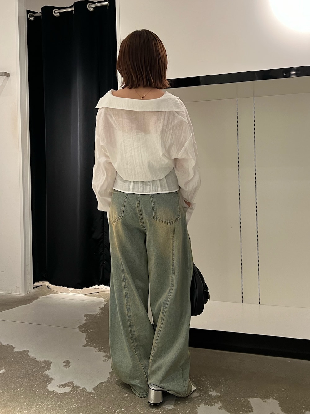 ホワイト系のシャツ/ブラウス、ブルー系のデニムパンツ、ブラック系のハンドバッグを着用したレディースの夏コーディネートの3枚目の写真