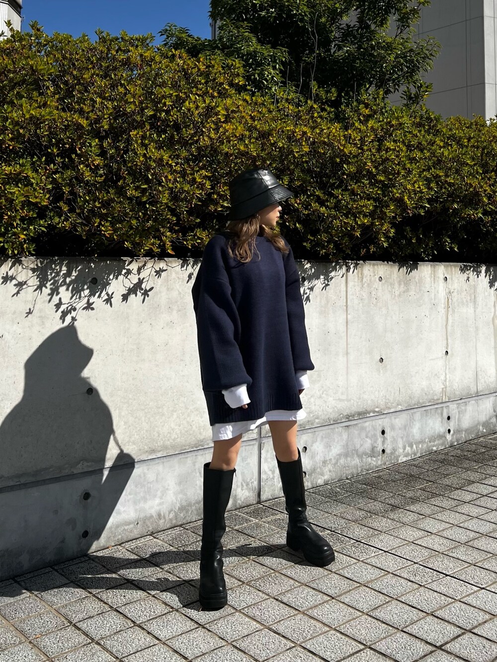 ブラック系のブーツ、ブラック系のショルダーバッグ、ホワイト系のTシャツ/カットソーを着用したレディースの秋コーディネートの2枚目の写真