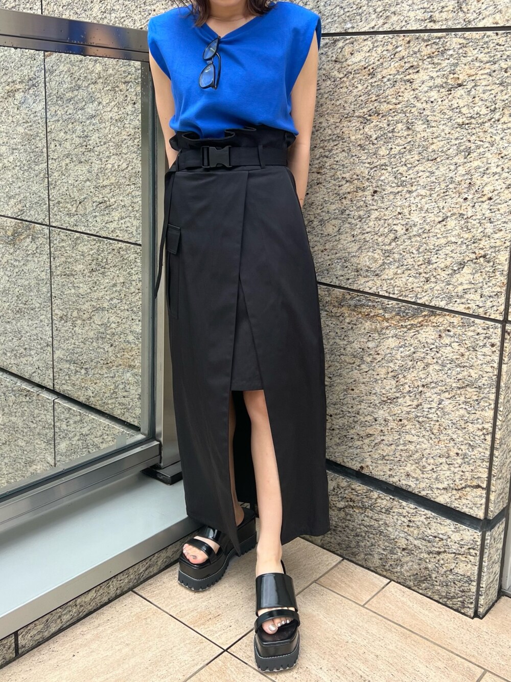 ブラック系のスカート、ブラック系のサンダル、ブルー系のTシャツ/カットソーを着用したレディースの夏コーディネートの6枚目の写真