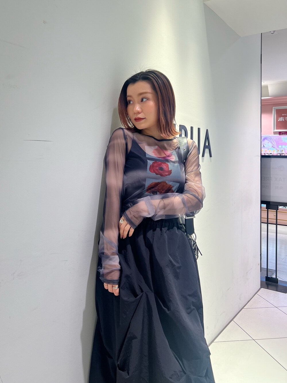 ブラック系のTシャツ/カットソー、ブラック系のスカート、ブラック系のブーツを着用したレディースの春コーディネートの5枚目の写真