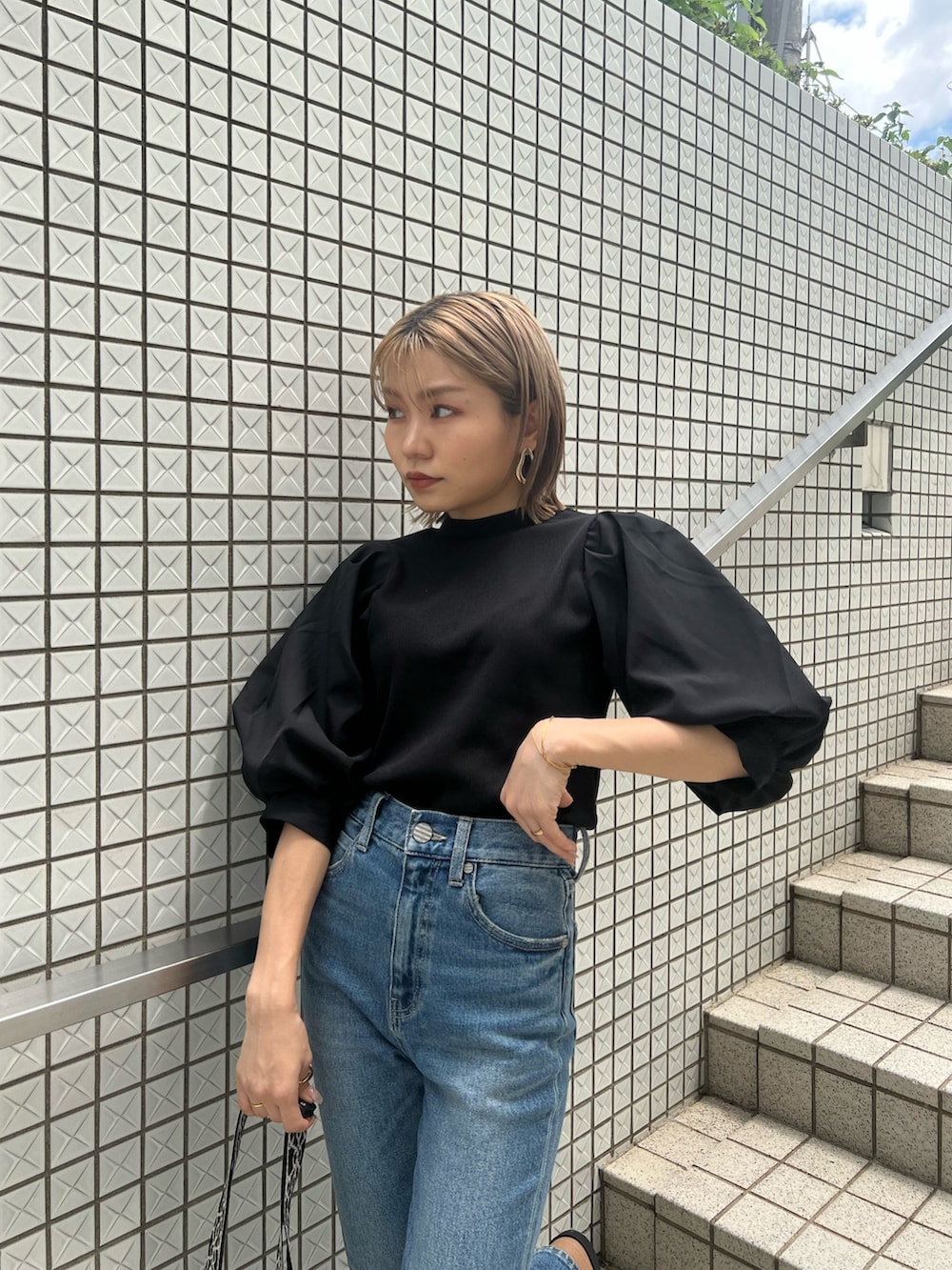 ブルー系のデニムパンツ、ブラック系のTシャツ/カットソー、ブラック系のショルダーバッグを着用したレディースの夏コーディネートの5枚目の写真