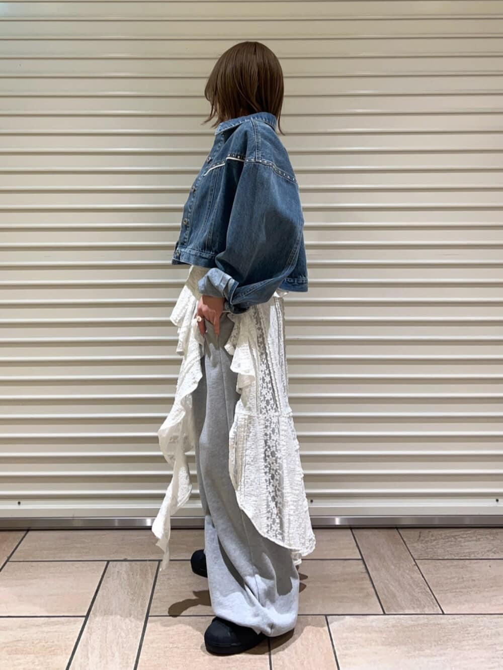 ブルー系のデニムジャケット、ホワイト系のワンピース、グレー系のその他パンツを着用したレディースの春コーディネートの2枚目の写真