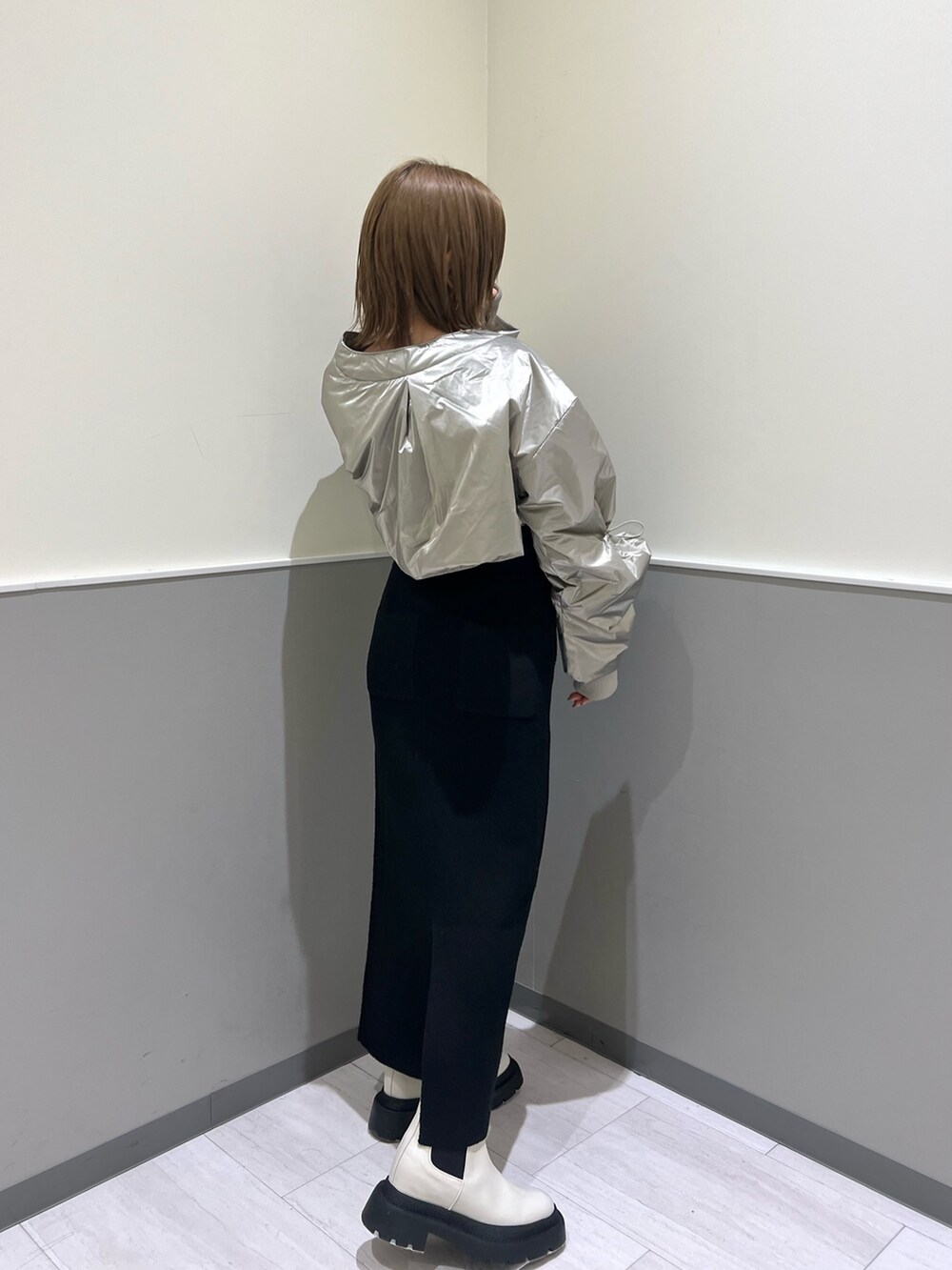 ブラック系のニット/セーター、シルバー系のブルゾン、ブラック系のスカートを着用したレディースの冬コーディネートの8枚目の写真