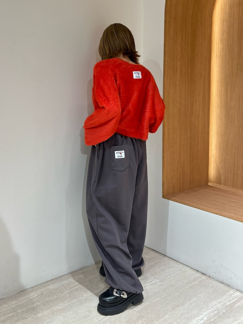 レッド系のニット/セーター、グレー系のその他パンツを着用したレディースの冬コーディネートの3枚目の写真