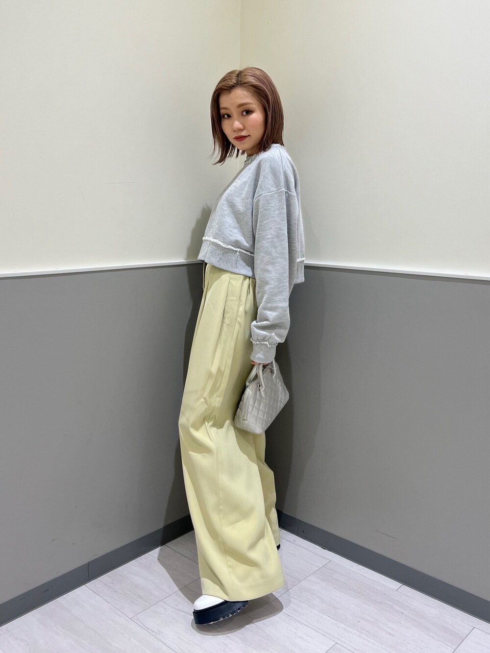 グレー系のスウェット、グリーン系のその他パンツ、シルバー系のハンドバッグを着用したレディースの冬コーディネートの3枚目の写真