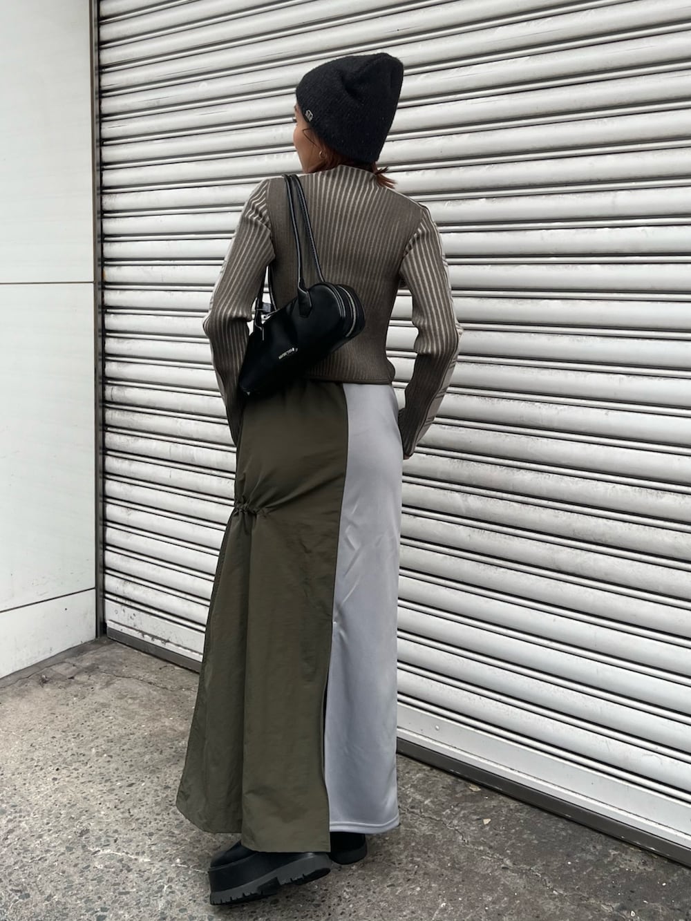 ブラック系のブーツ、グリーン系のニット/セーター、グリーン系のスカートを着用したレディースの秋コーディネートの4枚目の写真