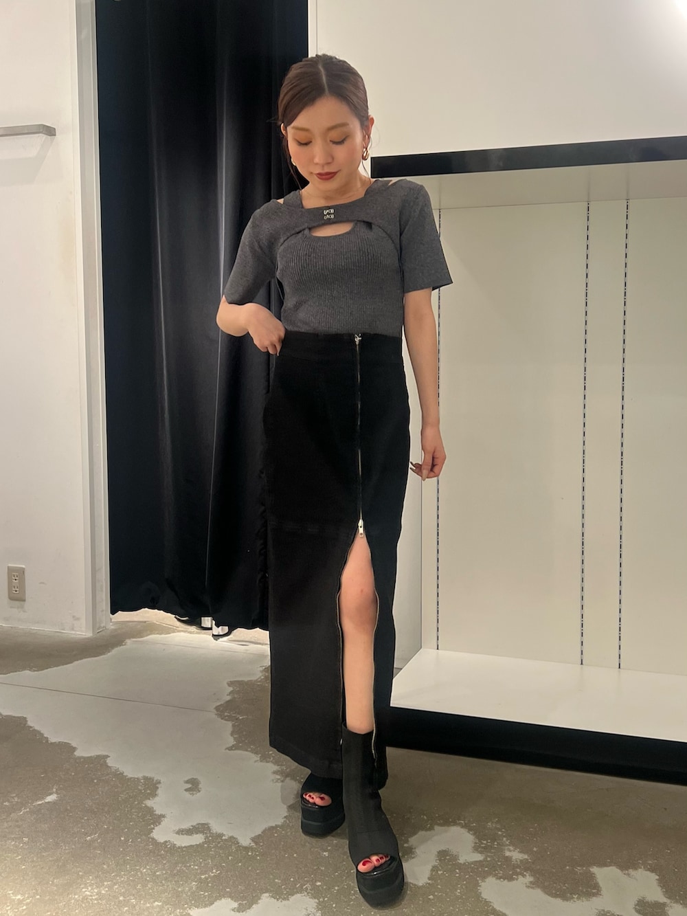 ブラック系のデニムスカート、その他のニット/セーター、ブラック系のサンダルを着用したレディースの夏コーディネートの3枚目の写真