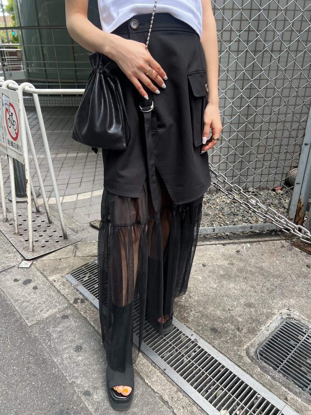 ホワイト系のTシャツ/カットソー、ブラック系のスカート、ブラック系のショルダーバッグを着用したレディースの春コーディネートの7枚目の写真