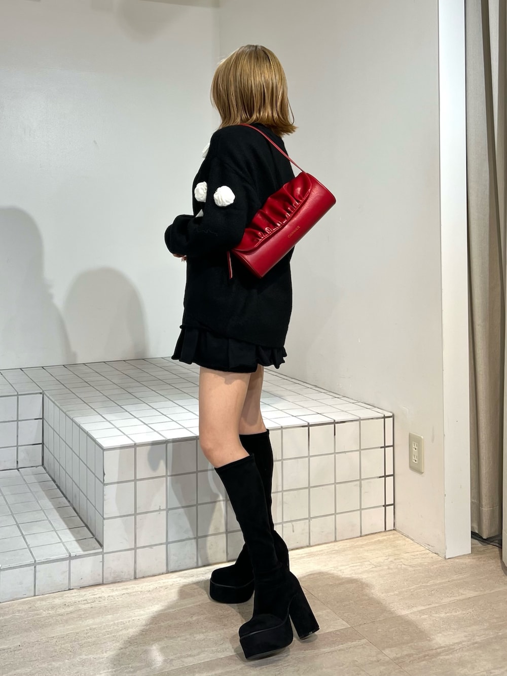 ブラック系のニット/セーター、ブラック系のその他パンツ、ブラック系のブーツを着用したレディースの冬コーディネートの2枚目の写真