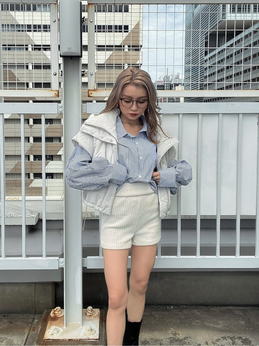 ブルー系のシャツ/ブラウス、ホワイト系のダウンベストを着用したレディースの秋コーディネートの6枚目の写真