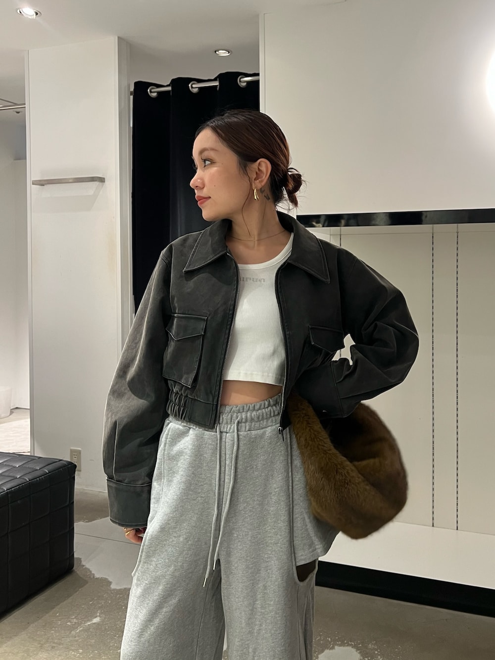 ブラック系のブルゾン、ホワイト系のTシャツ/カットソー、グレー系のスウェットパンツを着用したレディースの秋コーディネートの5枚目の写真