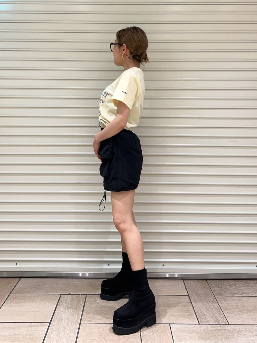 イエロー系のTシャツ/カットソー、ブラック系のスカートを着用したレディースの春コーディネートの2枚目の写真