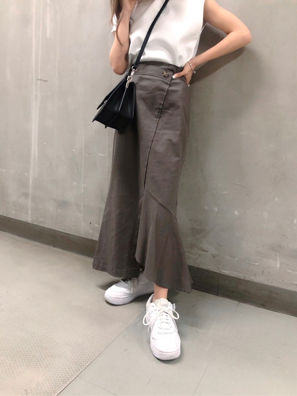 グレー系のスカート、ブラック系のハンドバッグ、ホワイト系のTシャツ/カットソーを着用したレディースの春コーディネートの4枚目の写真