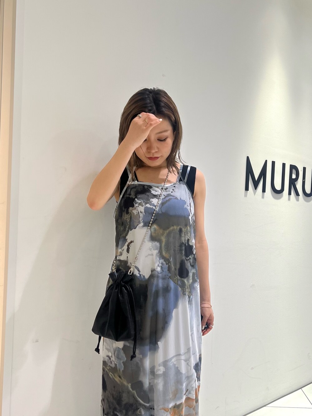 ブラック系のニット/セーター、グレー系のワンピース、ブラック系のショルダーバッグを着用したレディースの夏コーディネートの6枚目の写真