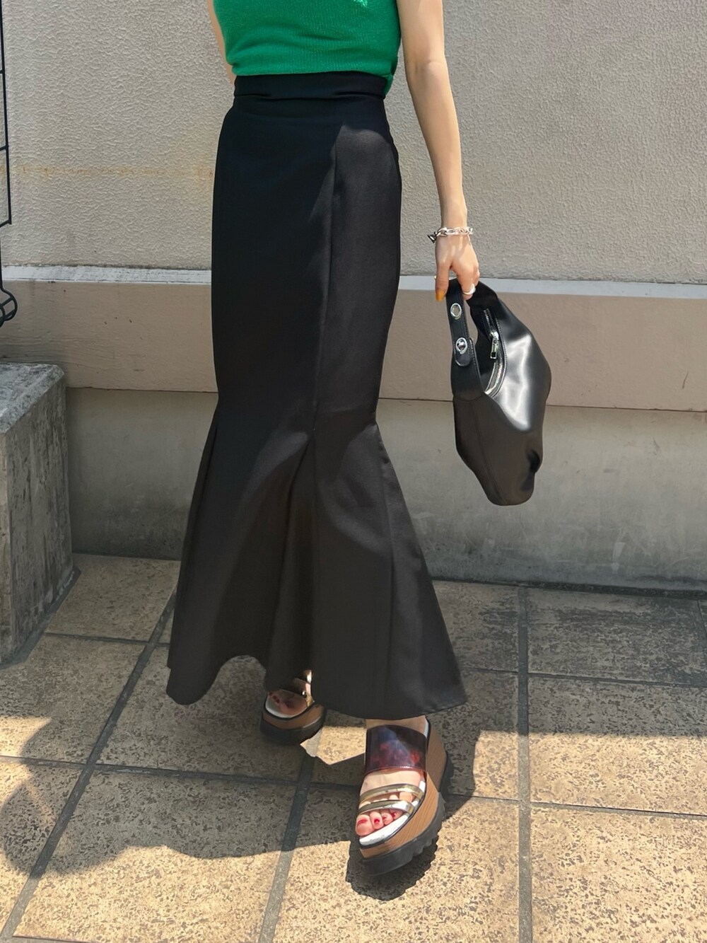 グリーン系のタンクトップ、ブラック系のスカート、その他のサンダルを着用したレディースの夏コーディネートの8枚目の写真