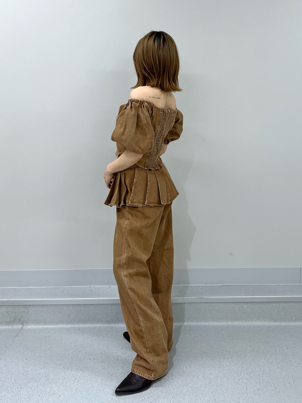 ブラウン系のシャツ/ブラウス、ブラウン系のデニムパンツ、ブラウン系のブーツを着用したレディースの春コーディネートの2枚目の写真