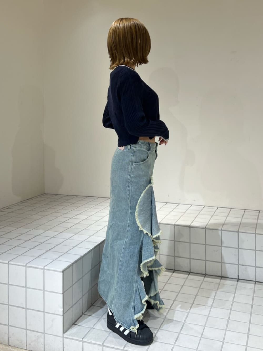 ブルー系のスカート、ブルー系のニット/セーターを着用したレディースの冬コーディネートの2枚目の写真