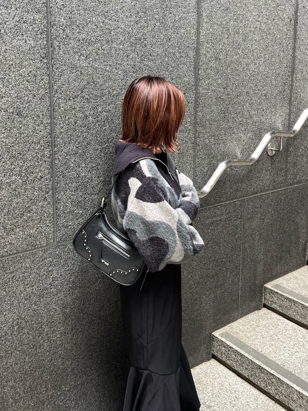 ブラック系のニット/セーター、ブラウン系のブーツ、ブラック系のスカートを着用したレディースの秋コーディネートの5枚目の写真