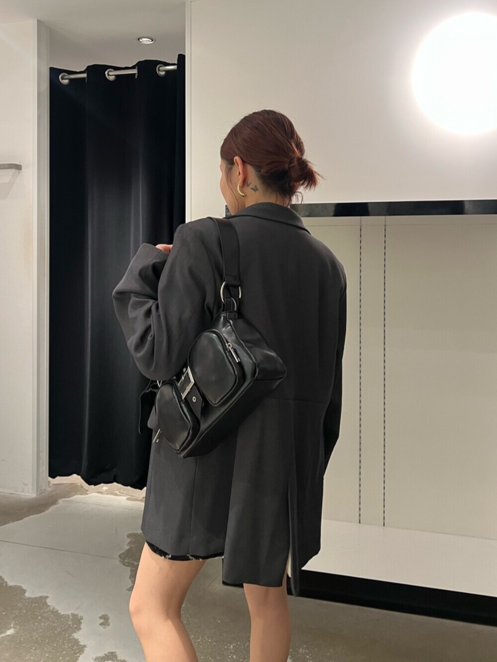 ブラック系のハンドバッグ、ブラウン系のブーツ、ブラック系のニット/セーターを着用したレディースの秋コーディネートの6枚目の写真