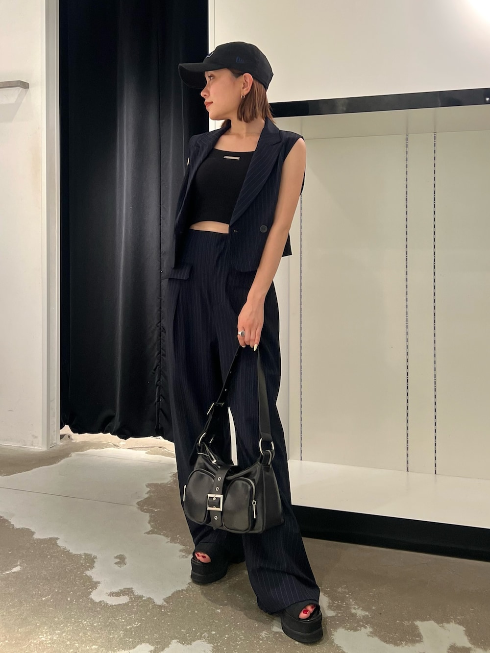 ブルー系のベスト、ブルー系のその他パンツ、ブラック系のキャミソールを着用したレディースの夏コーディネートの4枚目の写真