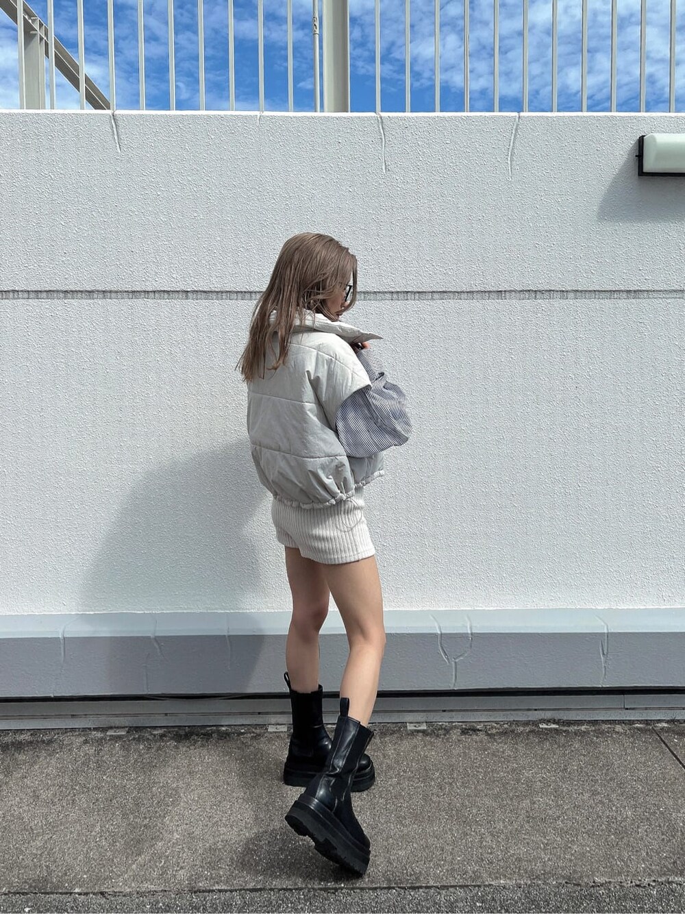 ブルー系のシャツ/ブラウス、ホワイト系のダウンベストを着用したレディースの秋コーディネートの2枚目の写真