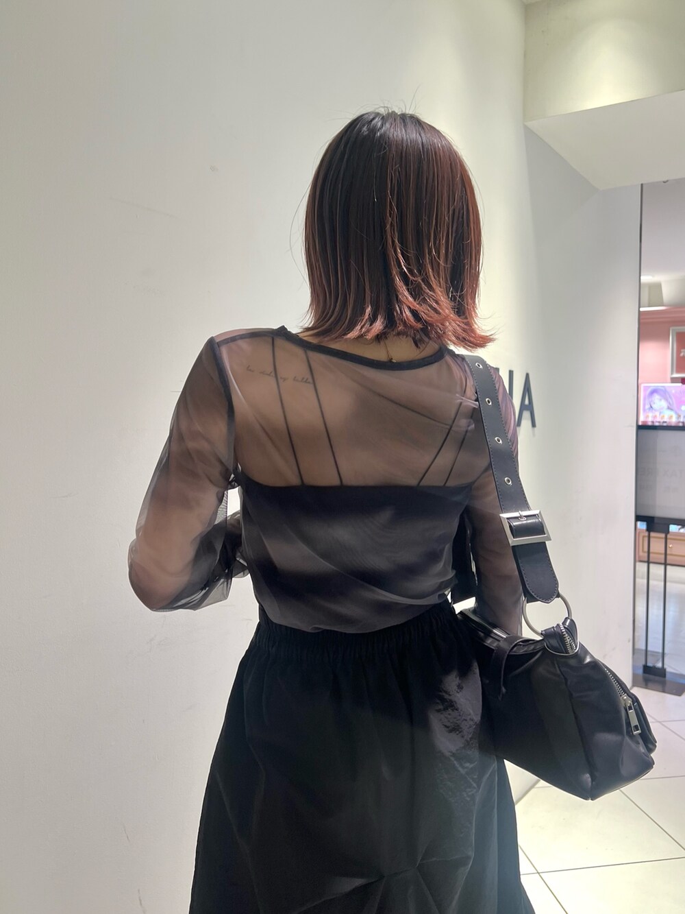 ブラック系のTシャツ/カットソー、ブラック系のスカート、ブラック系のブーツを着用したレディースの春コーディネートの6枚目の写真
