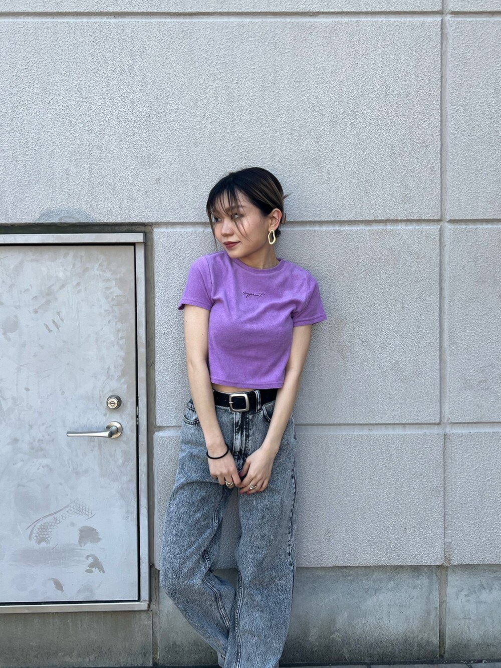 グレー系のデニムパンツ、パープル系のTシャツ/カットソー、ブラック系のベルトを着用したレディースの春コーディネートの5枚目の写真