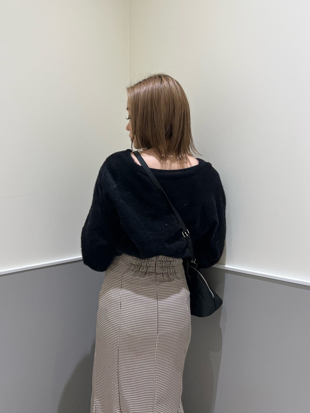 ブラック系のニット/セーター、その他のスカート、ブラック系のブーツを着用したレディースの冬コーディネートの6枚目の写真