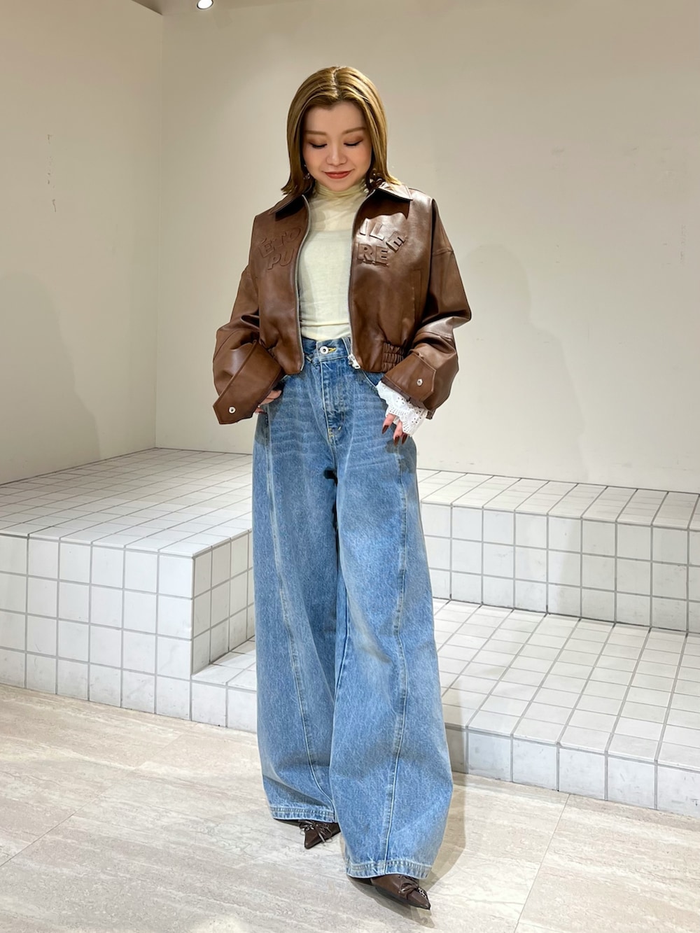 イエロー系のTシャツ/カットソー、ブルー系のその他パンツ、ブラウン系のブルゾンを着用したレディースの冬コーディネートの4枚目の写真