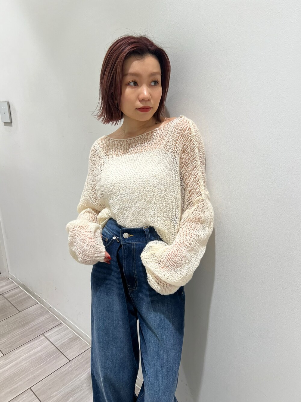 ブルー系のデニムパンツ、ホワイト系のニット/セーターを着用したレディースの秋コーディネートの5枚目の写真