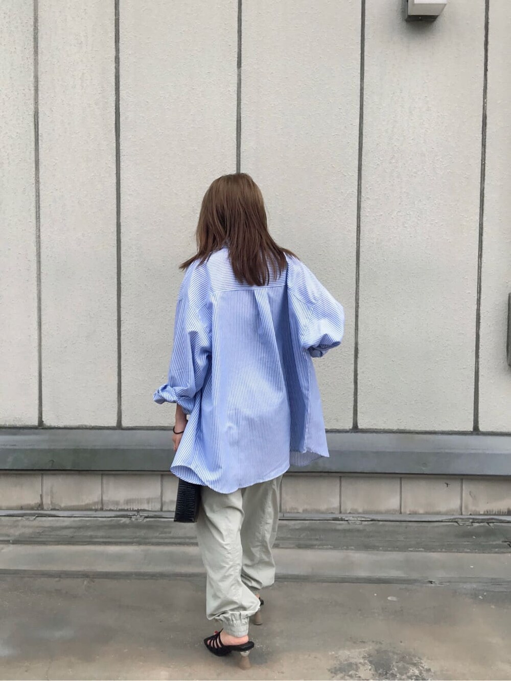 ベージュ系のカーゴパンツ、ブラック系のキャミソール、ブラック系のショルダーバッグを着用したレディースの夏コーディネートの3枚目の写真