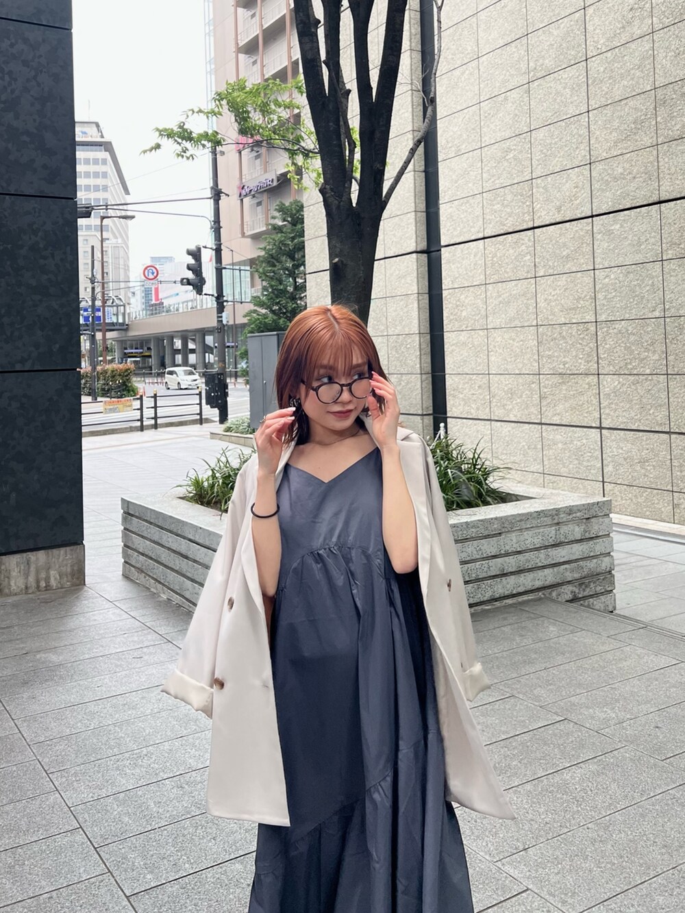 ベージュ系のテーラードジャケット、ブラウン系のニット/セーター、グレー系のワンピースを着用したレディースの春コーディネートの6枚目の写真