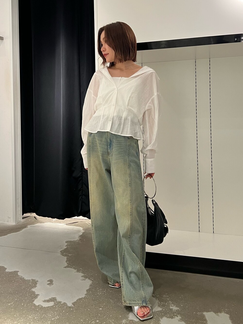 ホワイト系のシャツ/ブラウス、ブルー系のデニムパンツ、ブラック系のハンドバッグを着用したレディースの夏コーディネートの4枚目の写真