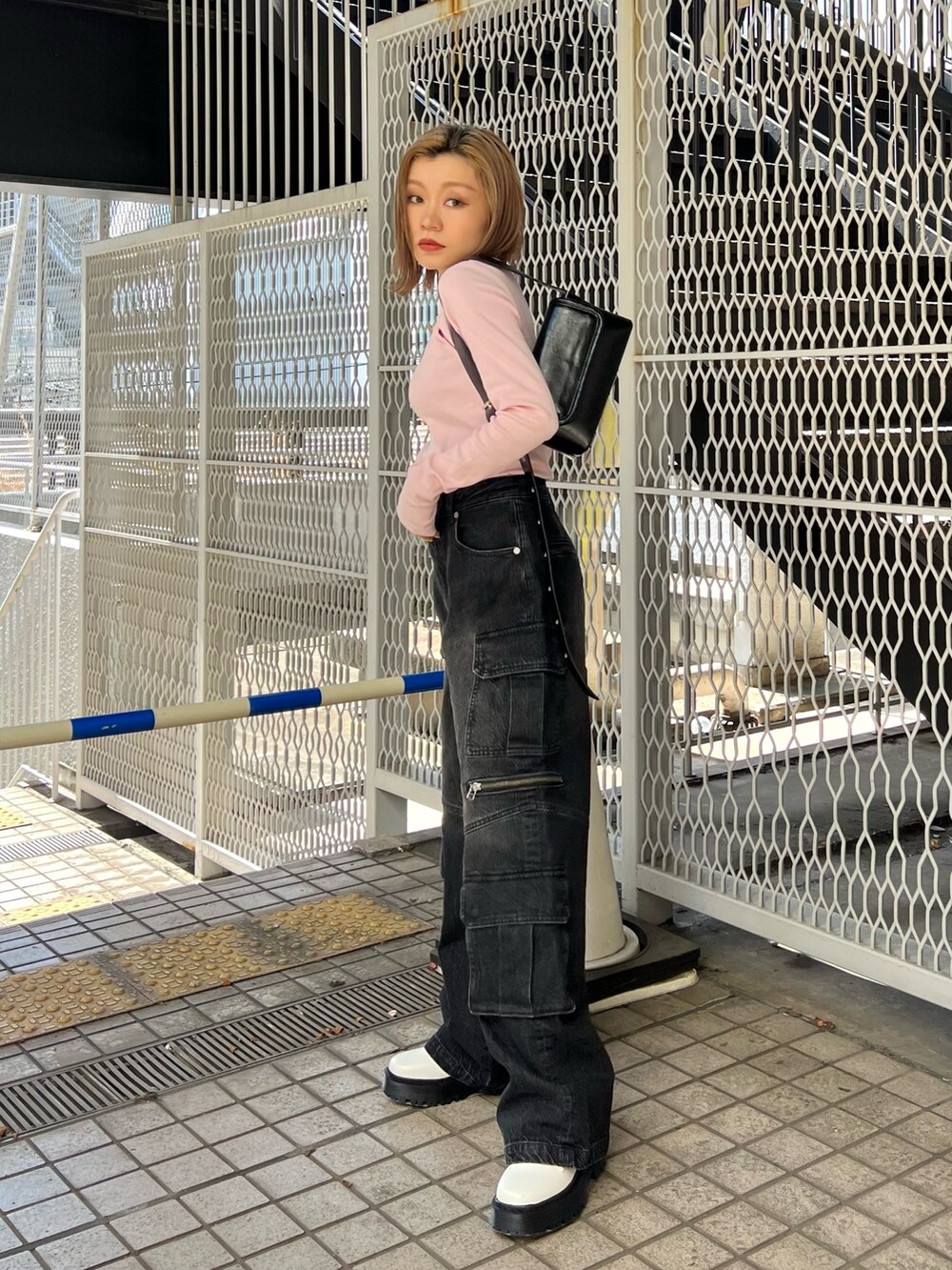 ピンク系のTシャツ/カットソー、ブラック系のデニムパンツ、ホワイト系のブーツを着用したレディースの冬コーディネートの2枚目の写真