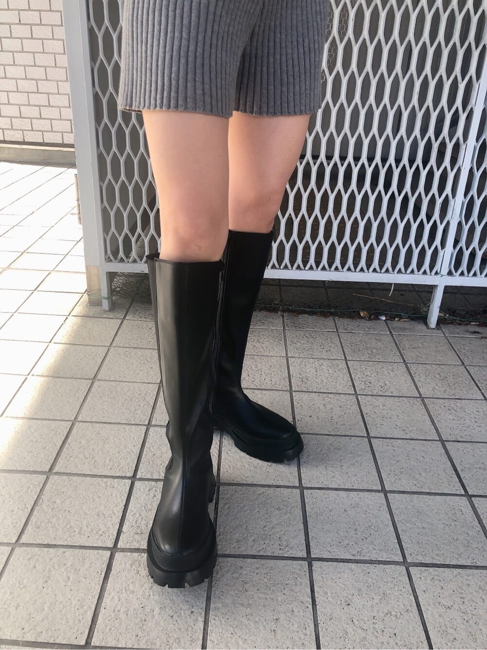 グレー系のその他パンツ、ブラック系のブーツ、ブラック系のダウンベストを着用したレディースの秋コーディネートの6枚目の写真