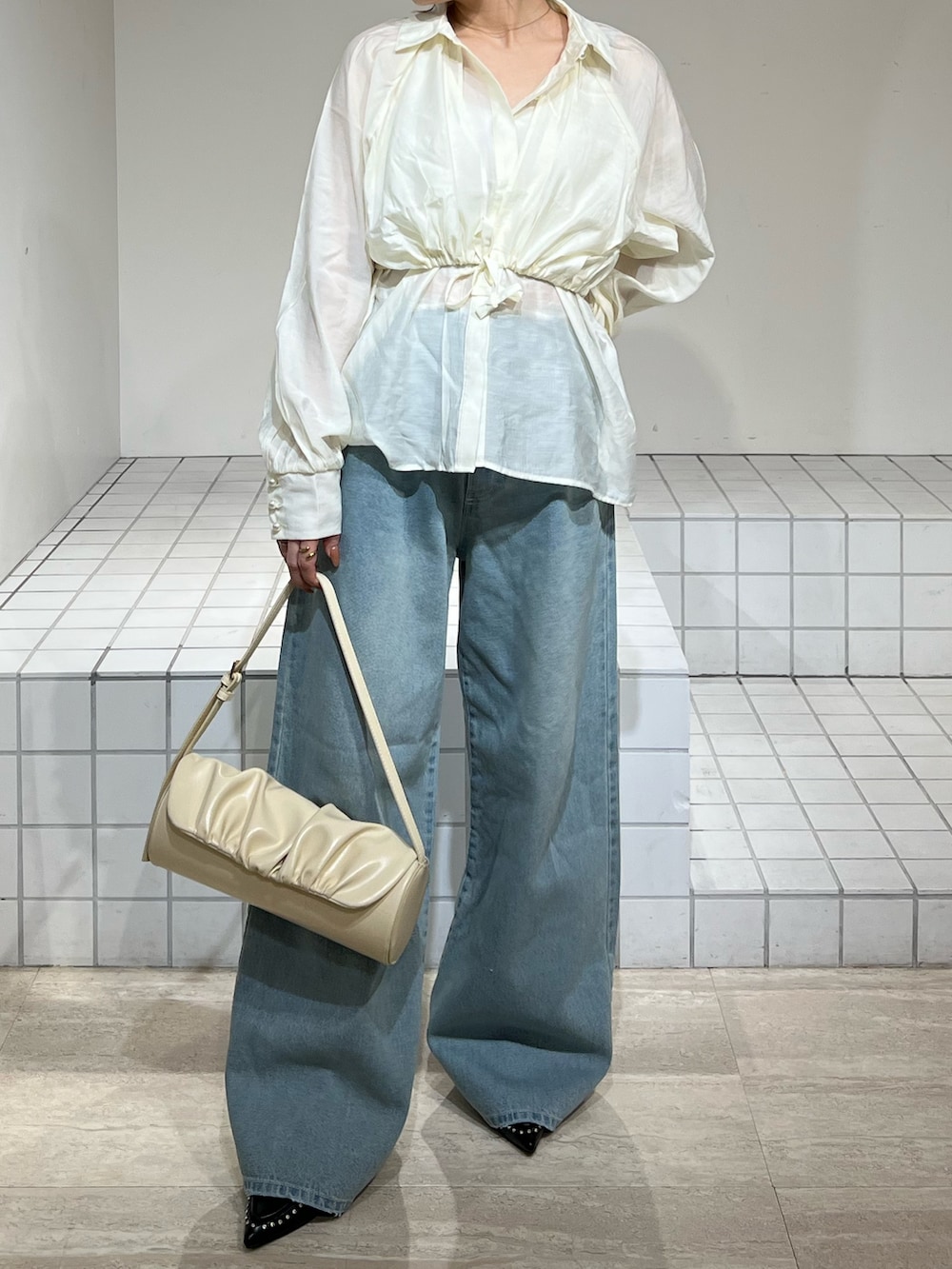 ホワイト系のシャツ/ブラウス、ブルー系のデニムパンツ、ブラック系のサンダルを着用したレディースの春コーディネートの5枚目の写真
