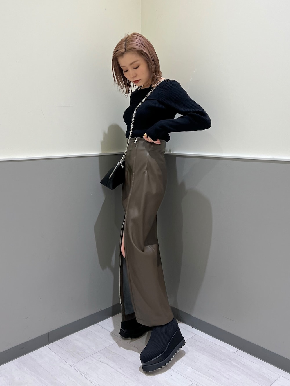 ブラック系のニット/セーター、ブラック系のブーツ、ブラウン系のスカートを着用したレディースの冬コーディネートの3枚目の写真