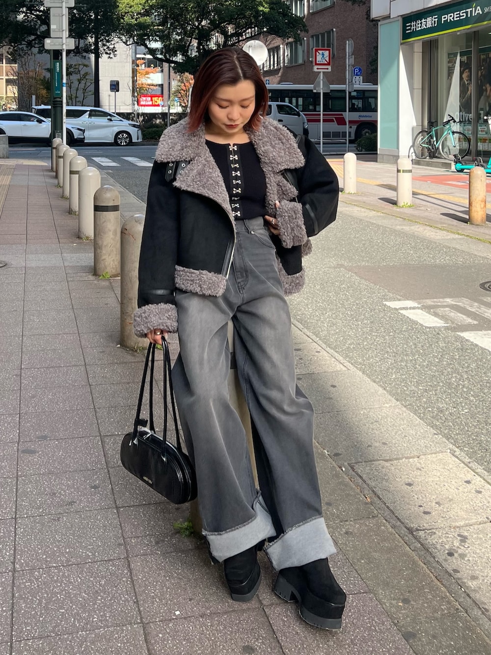 グレー系のデニムパンツ、ブラック系のニット/セーター、ブラック系のブーツを着用したレディースの冬コーディネートの4枚目の写真