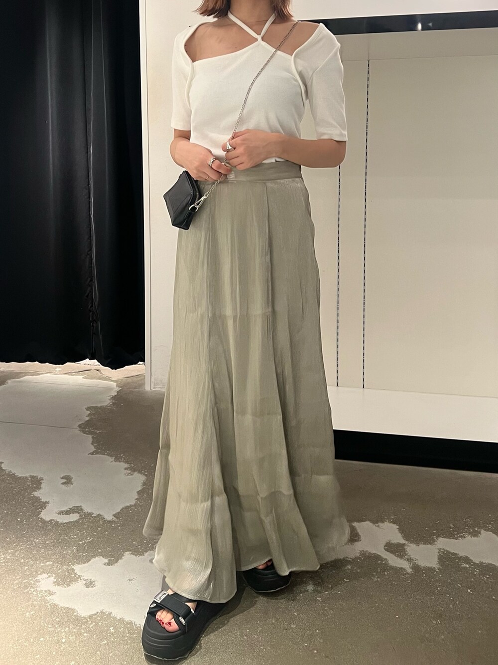 ブラック系のサンダル、ブラック系のショルダーバッグ、ホワイト系のTシャツ/カットソーを着用したレディースの夏コーディネートの5枚目の写真