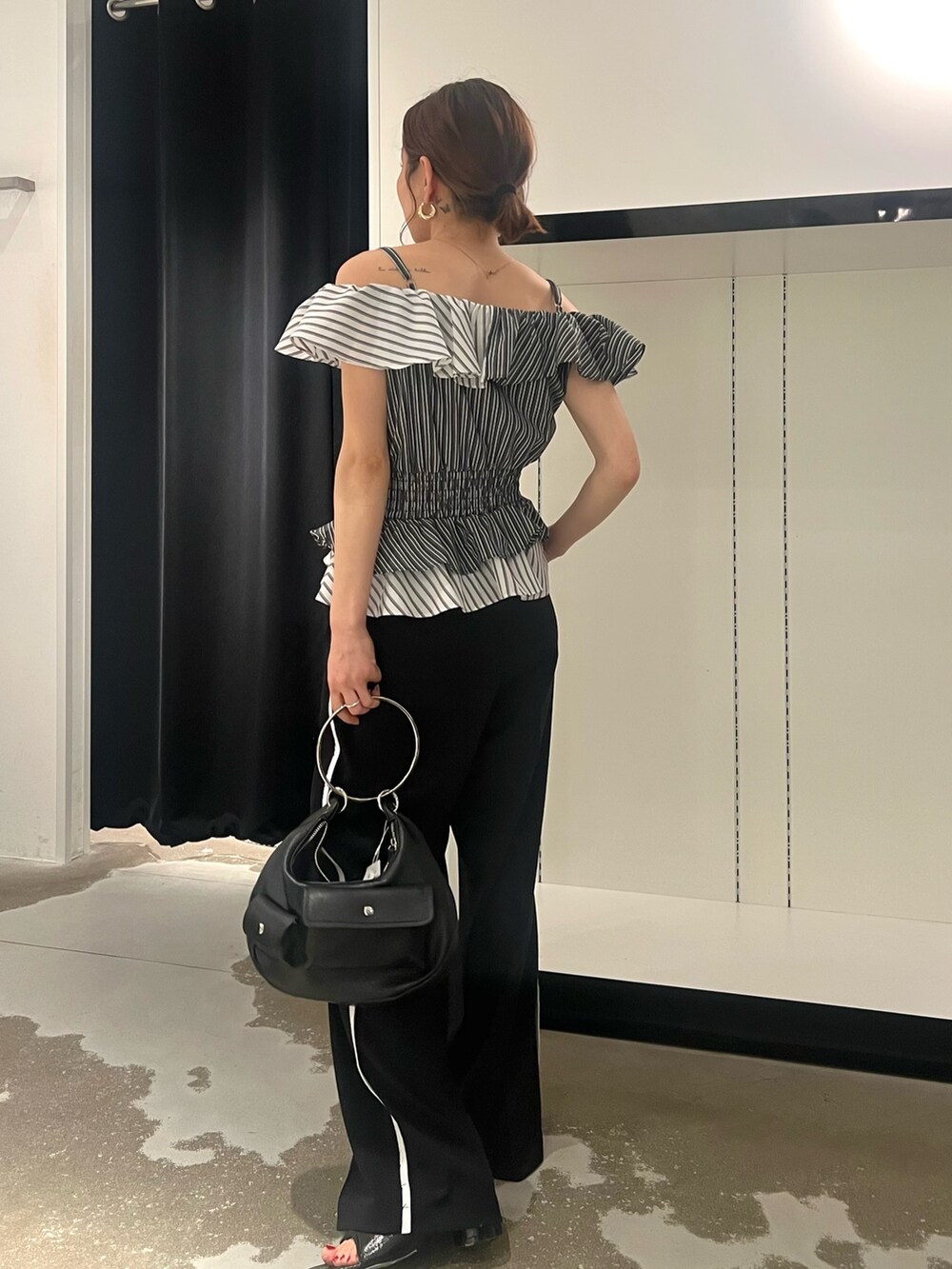 ブラック系のパンプス、ブラック系のハンドバッグ、ブラック系のその他パンツを着用したレディースの夏コーディネートの2枚目の写真