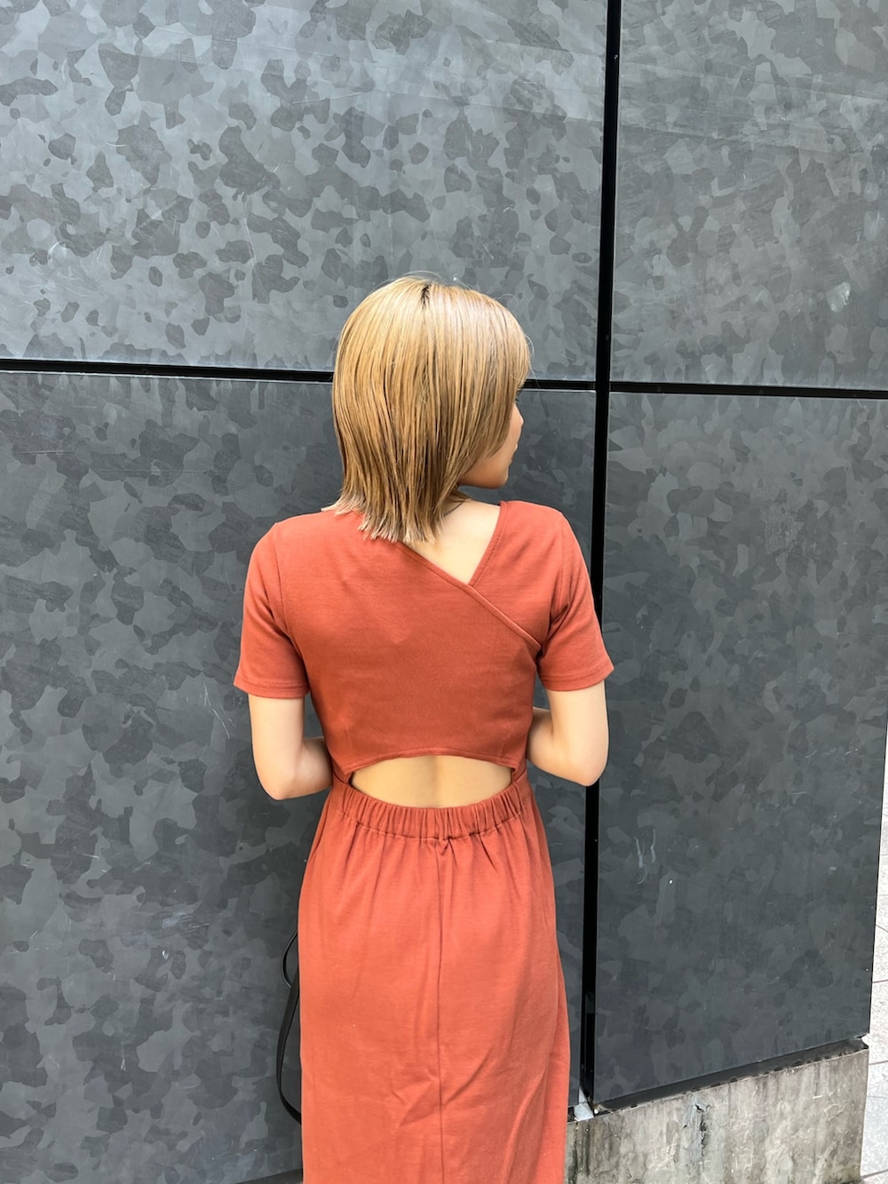 オレンジ系のワンピース、ブラック系のサンダルを着用したレディースの夏コーディネートの6枚目の写真