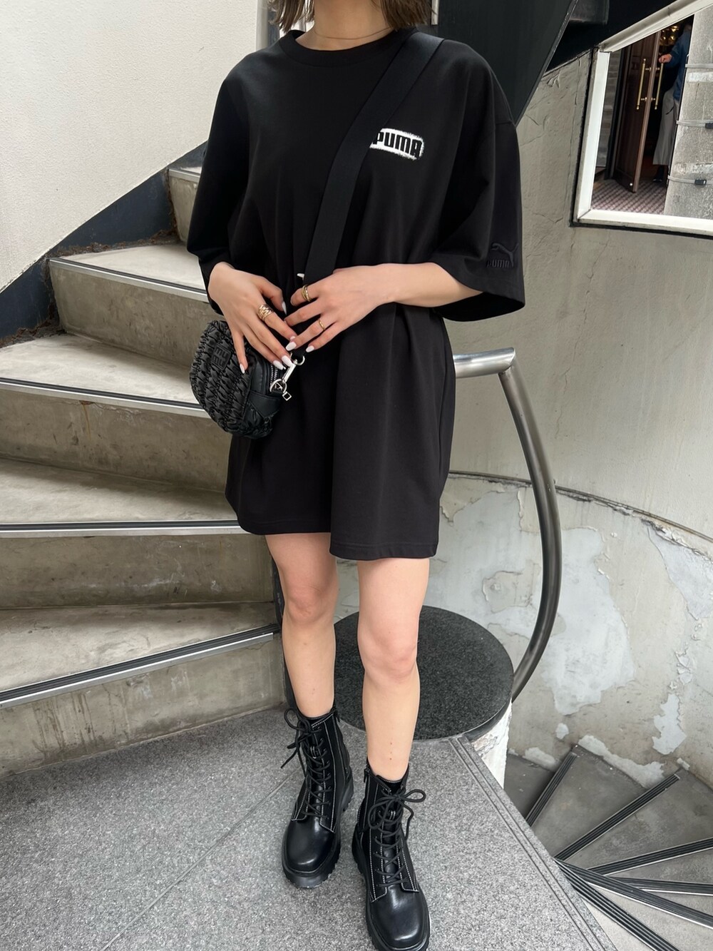 ブラック系のTシャツ/カットソー、ブラック系のブーツ、ブラック系のショルダーバッグを着用したレディースの春コーディネートの6枚目の写真