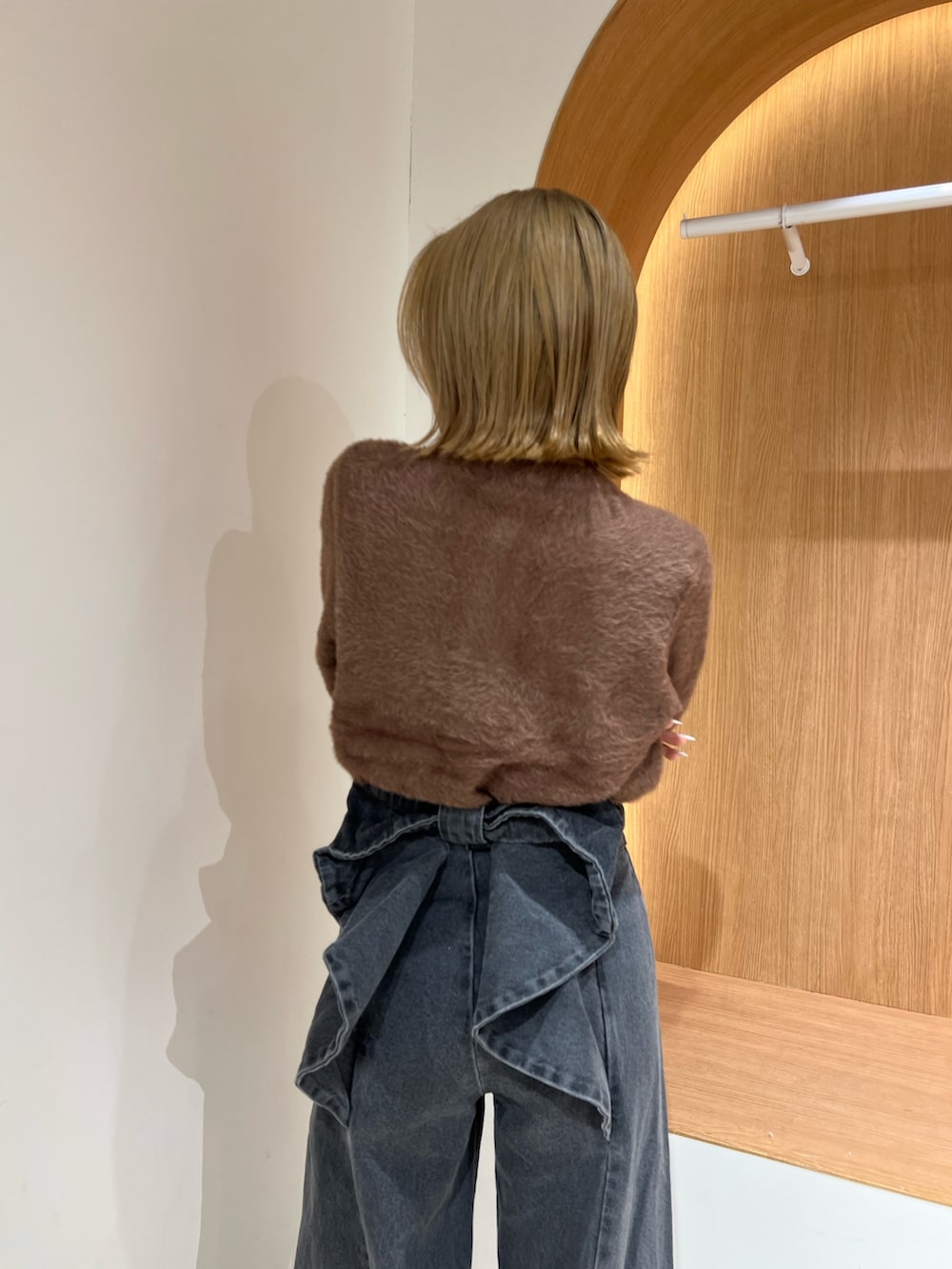 ブラウン系のカーディガン/ボレロ、ブラック系のデニムパンツ、ブラウン系のブーツを着用したレディースの冬コーディネートの5枚目の写真