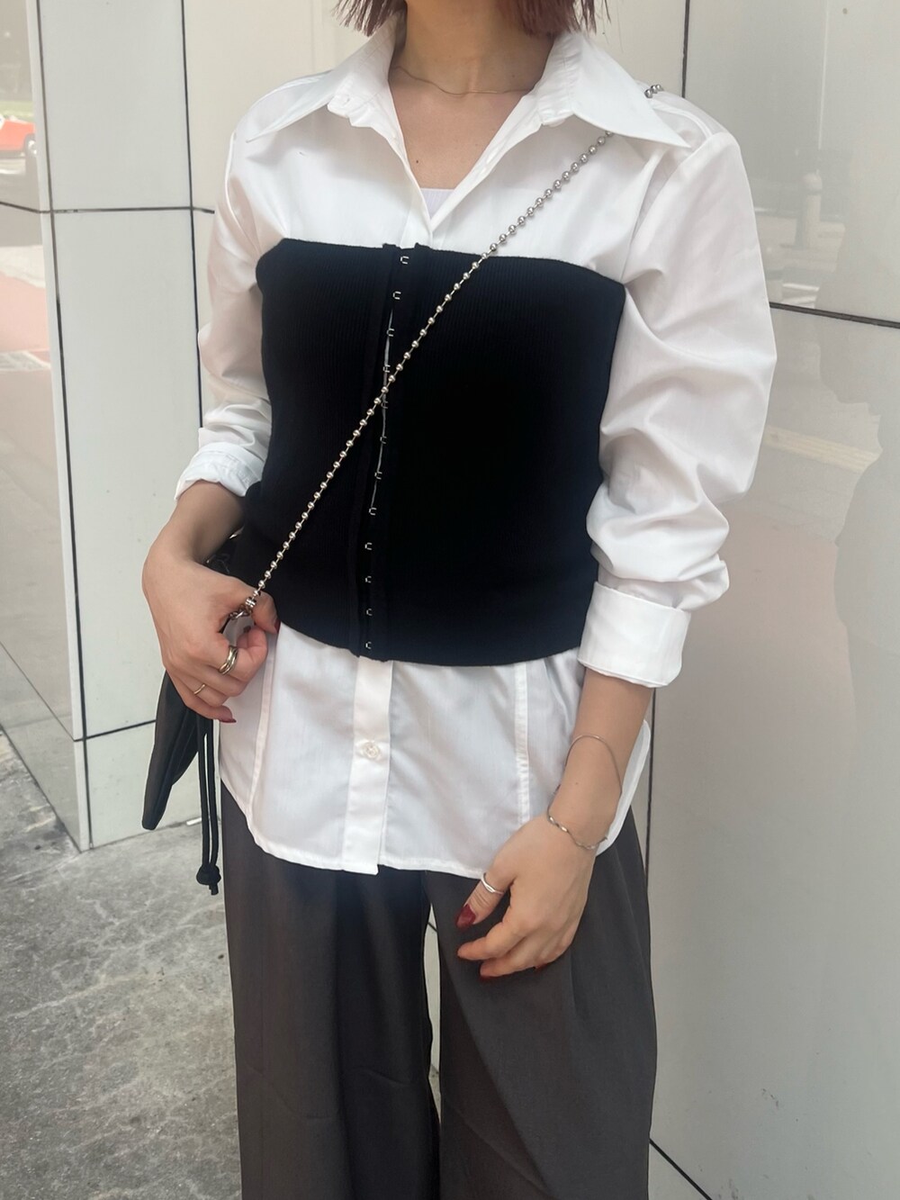 ブラック系のブーツ、ホワイト系のシャツ/ブラウス、ブラック系のニット/セーターを着用したレディースの秋コーディネートの7枚目の写真