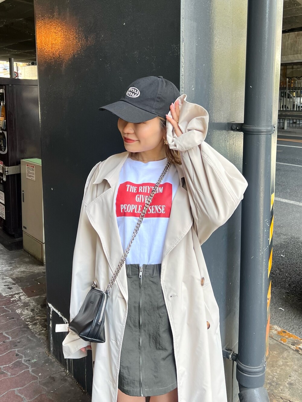 ブラック系のブーツ、ホワイト系のトレンチコート、ホワイト系のTシャツ/カットソーを着用したレディースの春コーディネートの5枚目の写真