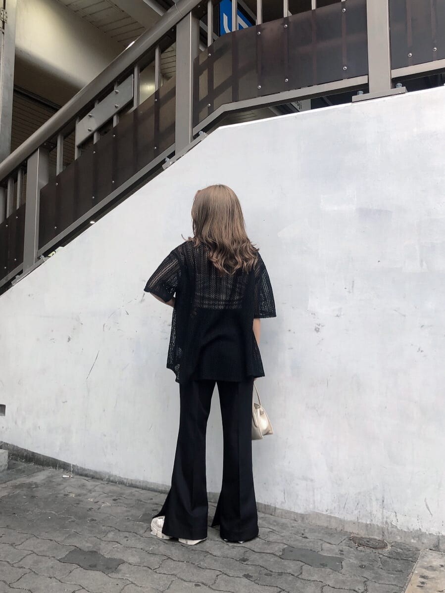 ブラック系のスラックス、ホワイト系のサンダル、ブラック系のシャツ/ブラウスを着用したレディースの春コーディネートの2枚目の写真