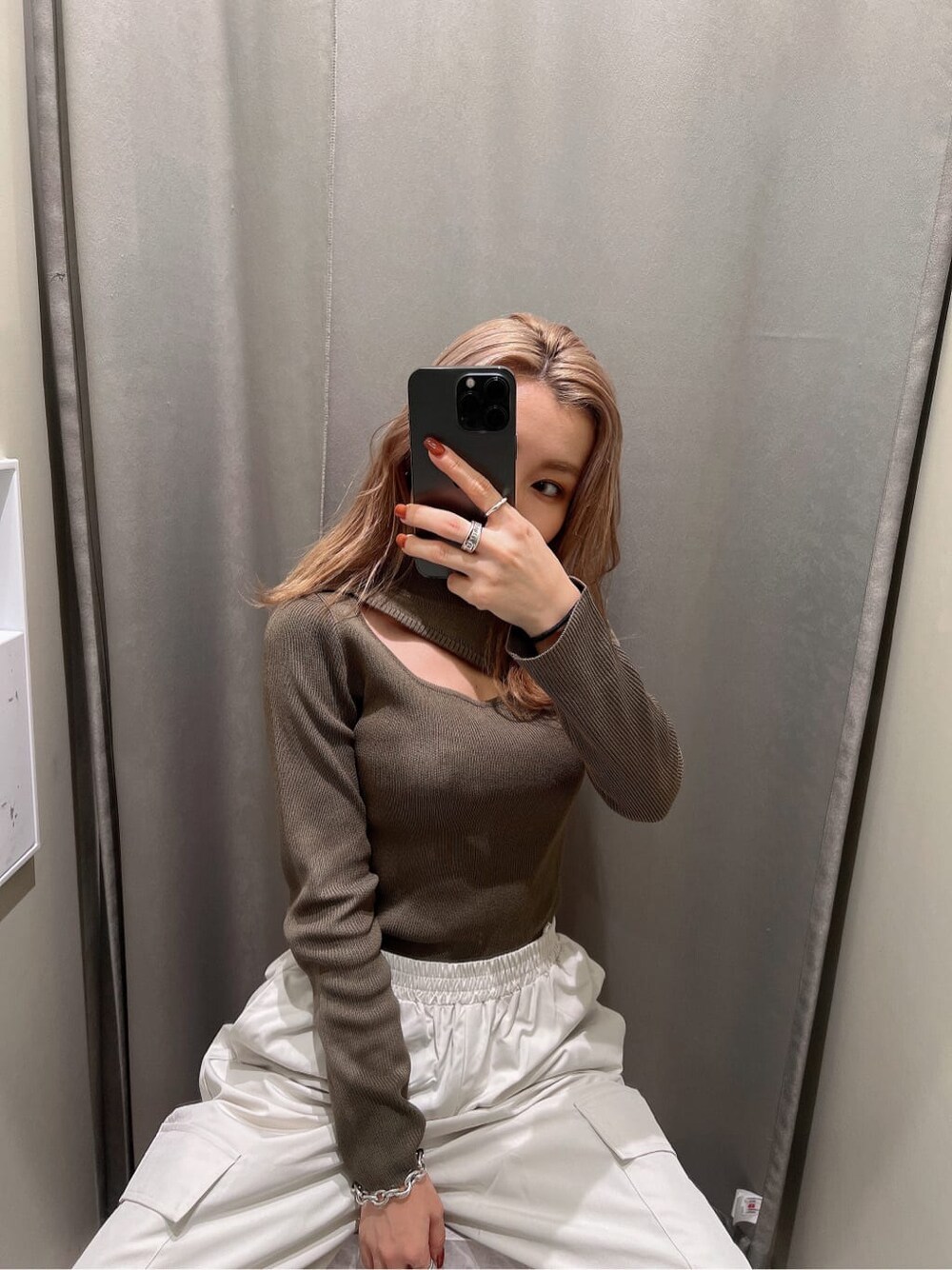 ブラック系のブーツ、ブラウン系のニット/セーター、ホワイト系のカーゴパンツを着用したレディースの秋コーディネートの5枚目の写真