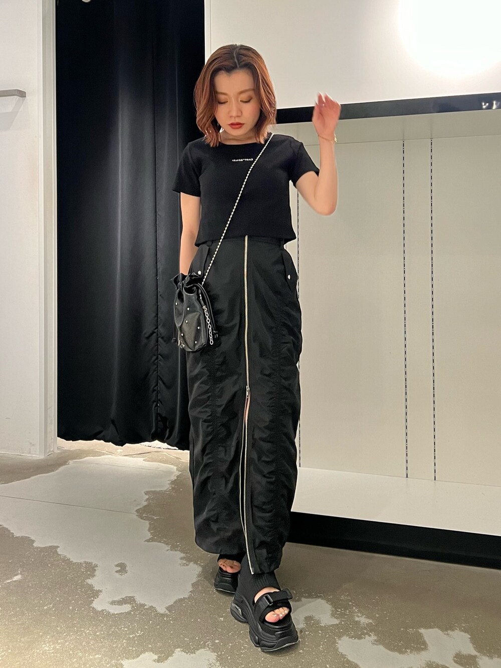 ブラック系のTシャツ/カットソー、ブラック系のサンダル、ブラック系のスカートを着用したレディースの春コーディネートの4枚目の写真