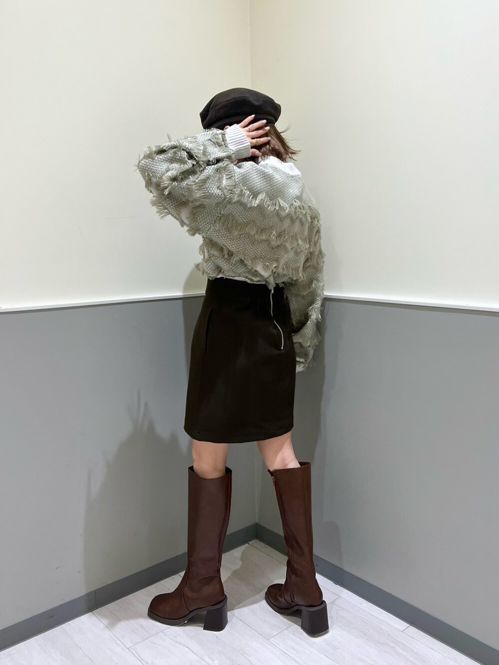 ベージュ系のニット/セーター、ブラウン系のスカート、ブラウン系のブーツを着用したレディースの秋コーディネートの3枚目の写真