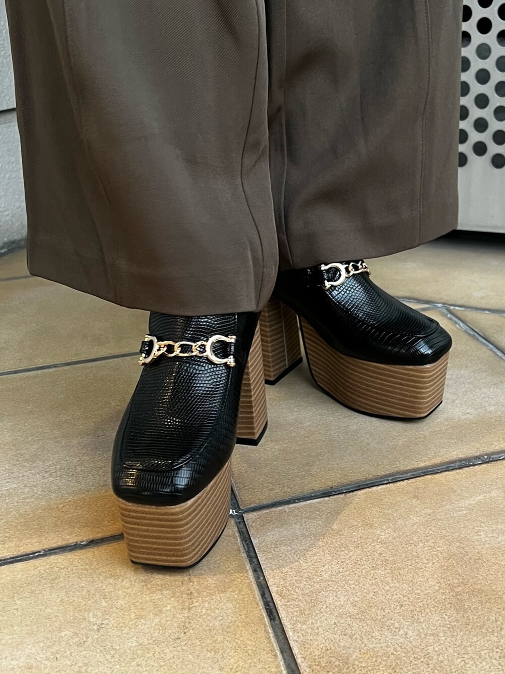 ブラック系のニット/セーター、ブラウン系のスラックス、ブラック系のローファーを着用したレディースの冬コーディネートの8枚目の写真